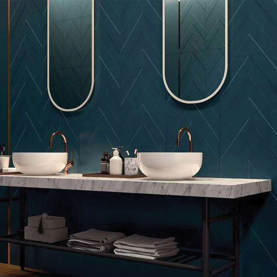 Deep Desire bathroom vanity with deep green 3D textured wall tiles in a chevron layout, dual round basins, and a marble countertop.