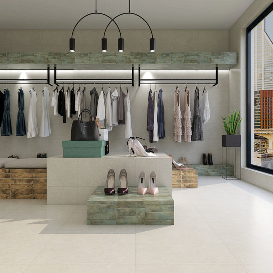 Modern boutique interior featuring Formanta Libra stone-effect porcelain floor tiles with Fire & Earth Series Emerald Patina and Burnished Gold metal-effect subway tiles, styled in a calm, refined design.