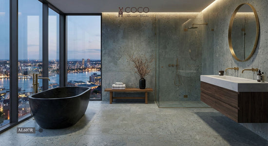 Modern luxury bathroom with Patina Series Grigio Azzurro matt 604x604 blue-grey concrete-effect porcelain tiles on floor and walls, styled with brass fixtures and skyline views.