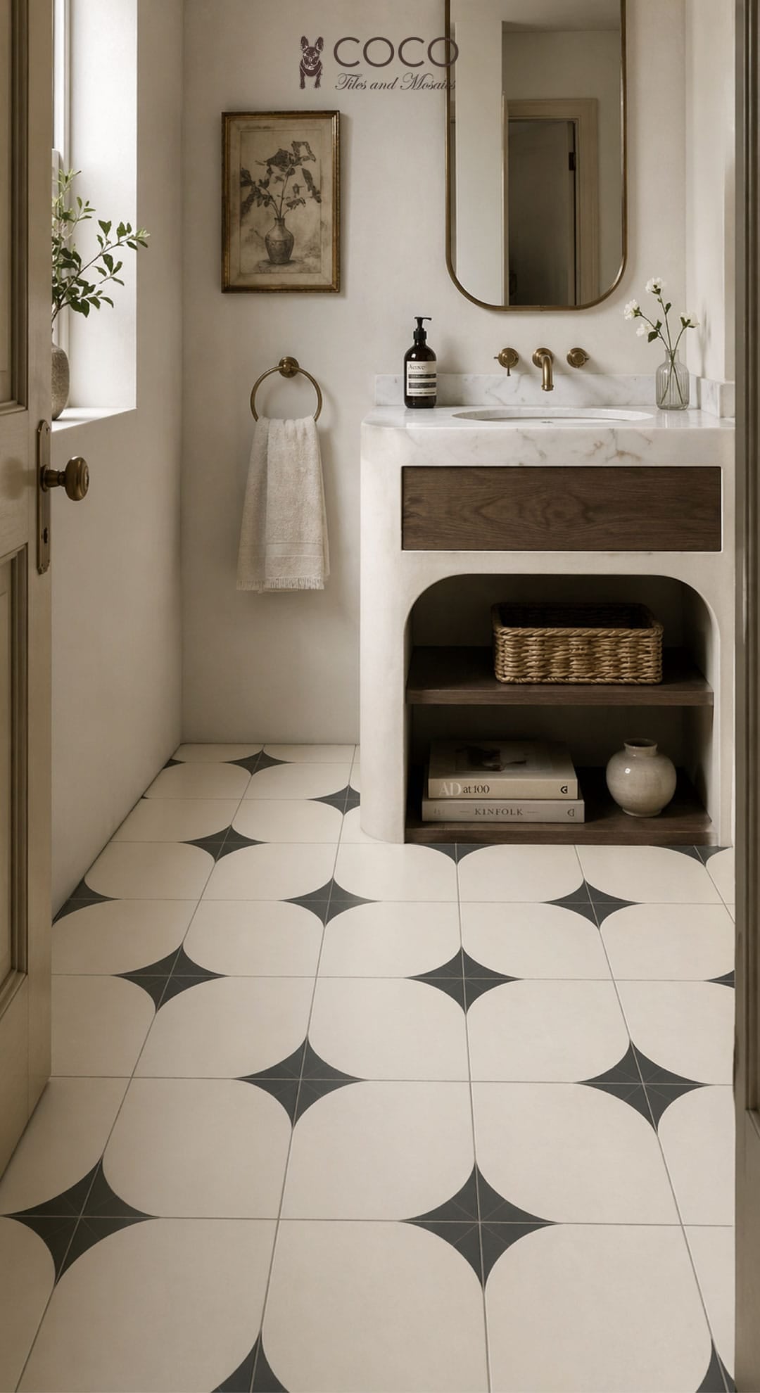 Small powder room with Arc After Dark Matte 300x300mm porcelain floor tile from COCO Tiles & Mosaics in warm ivory with fern green quarter-arc petal pattern, styled with a marble vanity, timber drawer, brushed brass tapware and arched mirror.
