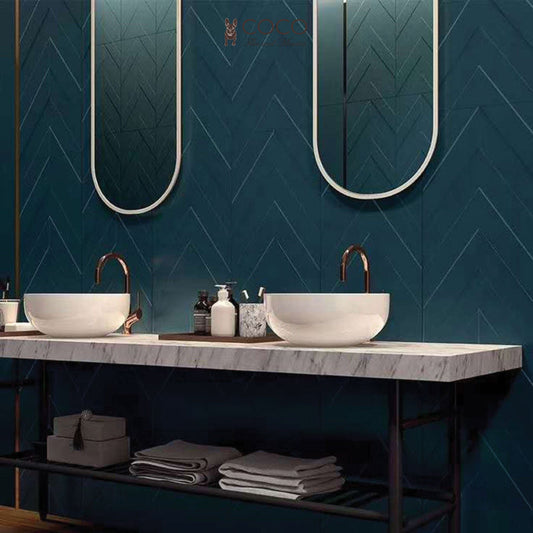 Deep Desire bathroom vanity with deep green 3D textured wall tiles in a chevron layout, dual round basins, and a marble countertop.