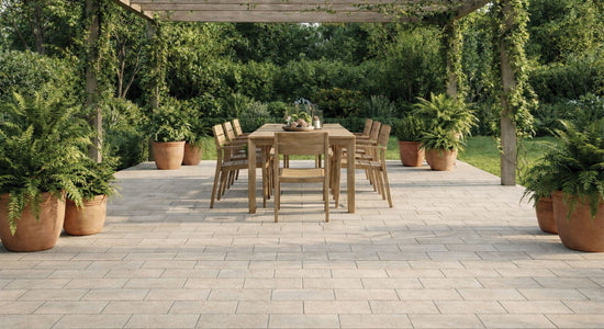Capri Calm outdoor tile look featuring Arcadia Ancient Whisper Textured 225x453mm porcelain tiles in a light stone finish, laid in a staggered pattern under a pergola with timber dining setting and lush greenery.