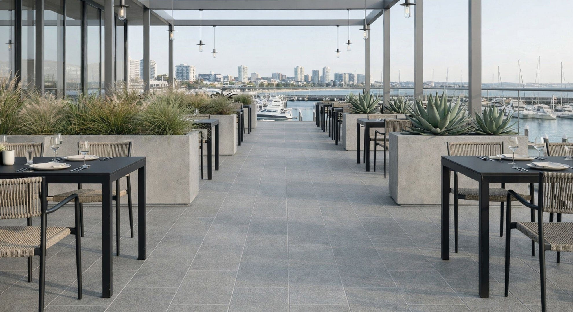 Modern rooftop terrace with Arcadia Series Eastern Opulence textured 225x453mm grey stone-look porcelain outdoor tiles laid in a brick pattern.